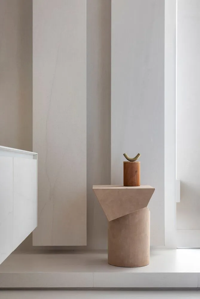 A minimalist side table with a terrazzo finish, featuring a single flowerpot on top.