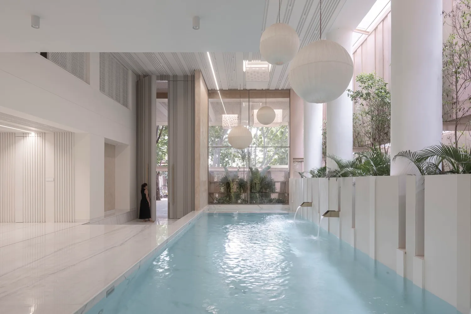 Modern minimalist residential area with a white marble pool on a clean, white marble floor.