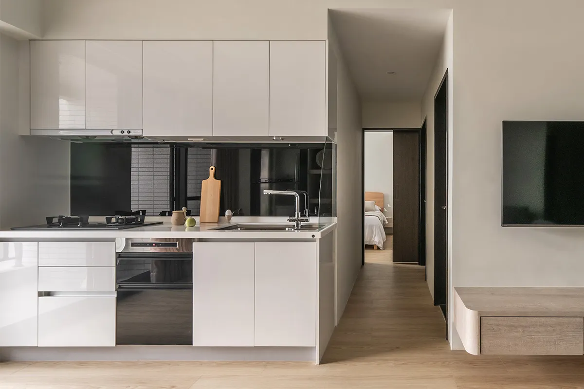 Modern residential kitchen with minimalist design, featuring white cabinetry and minimalist decor.