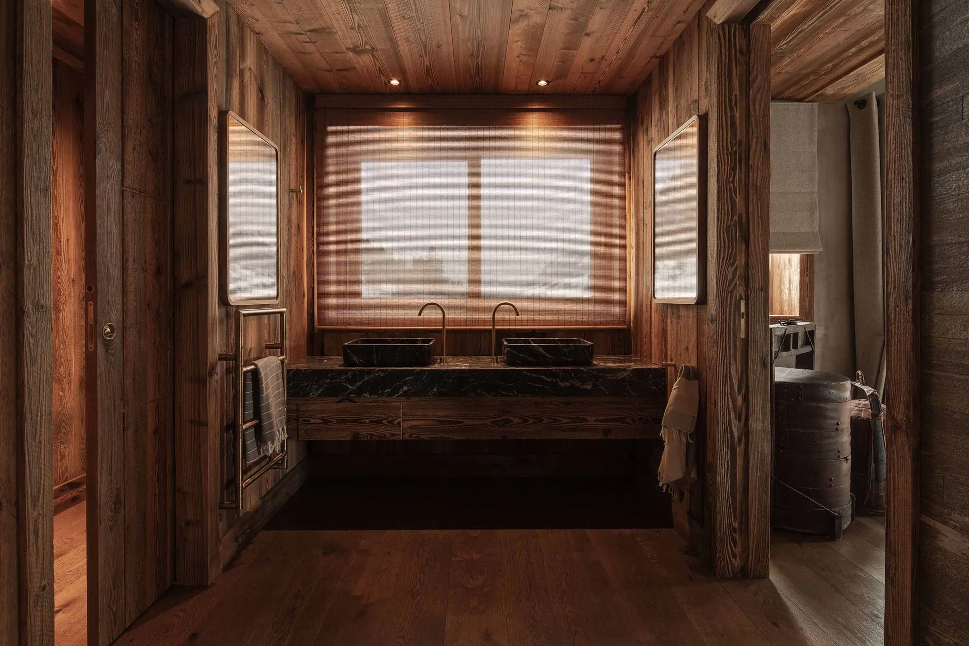 A rustic bathroom featuring wooden walls and marble sinks.
