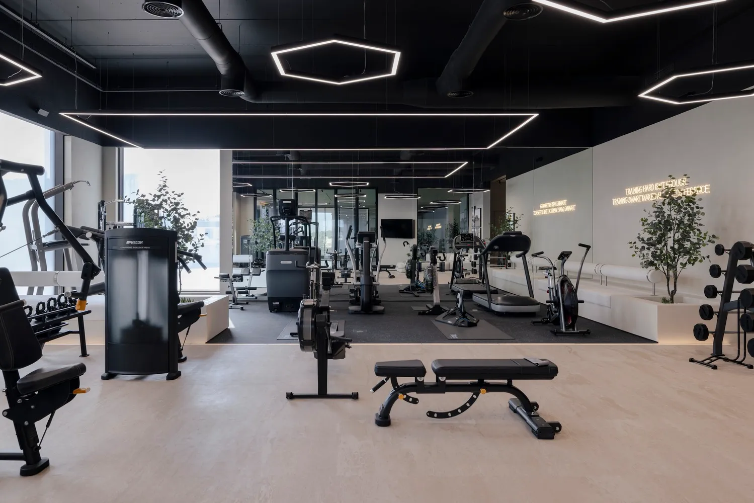 Modern, minimalist gym interior with metal, glass, and concrete materials.