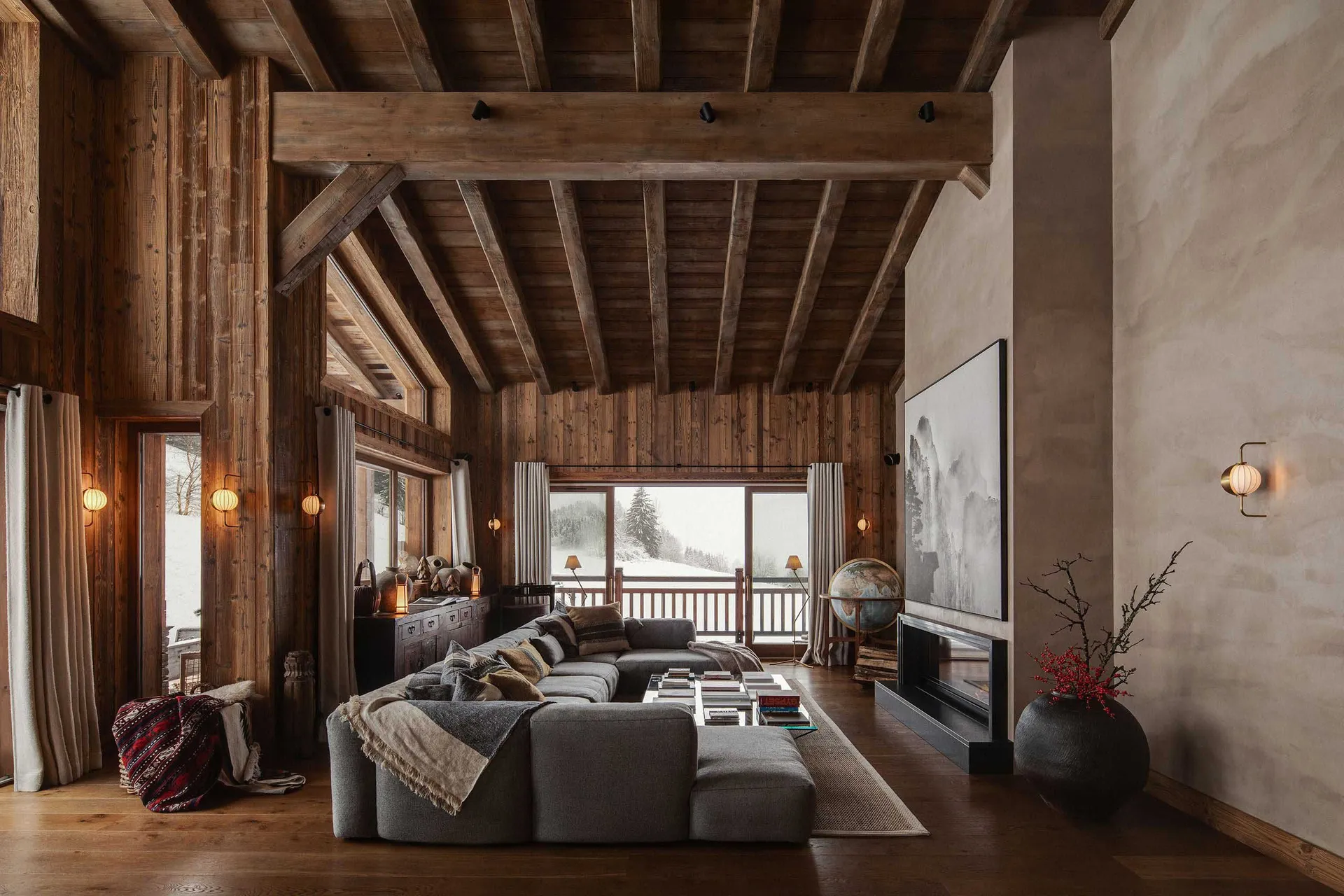 Modern living room with dark wooden walls, exposed beams, and a large sectional sofa.