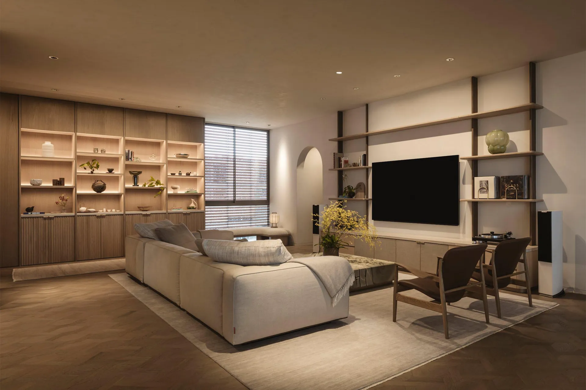 A minimalist living room with a large sofa, wooden shelves, and a TV.