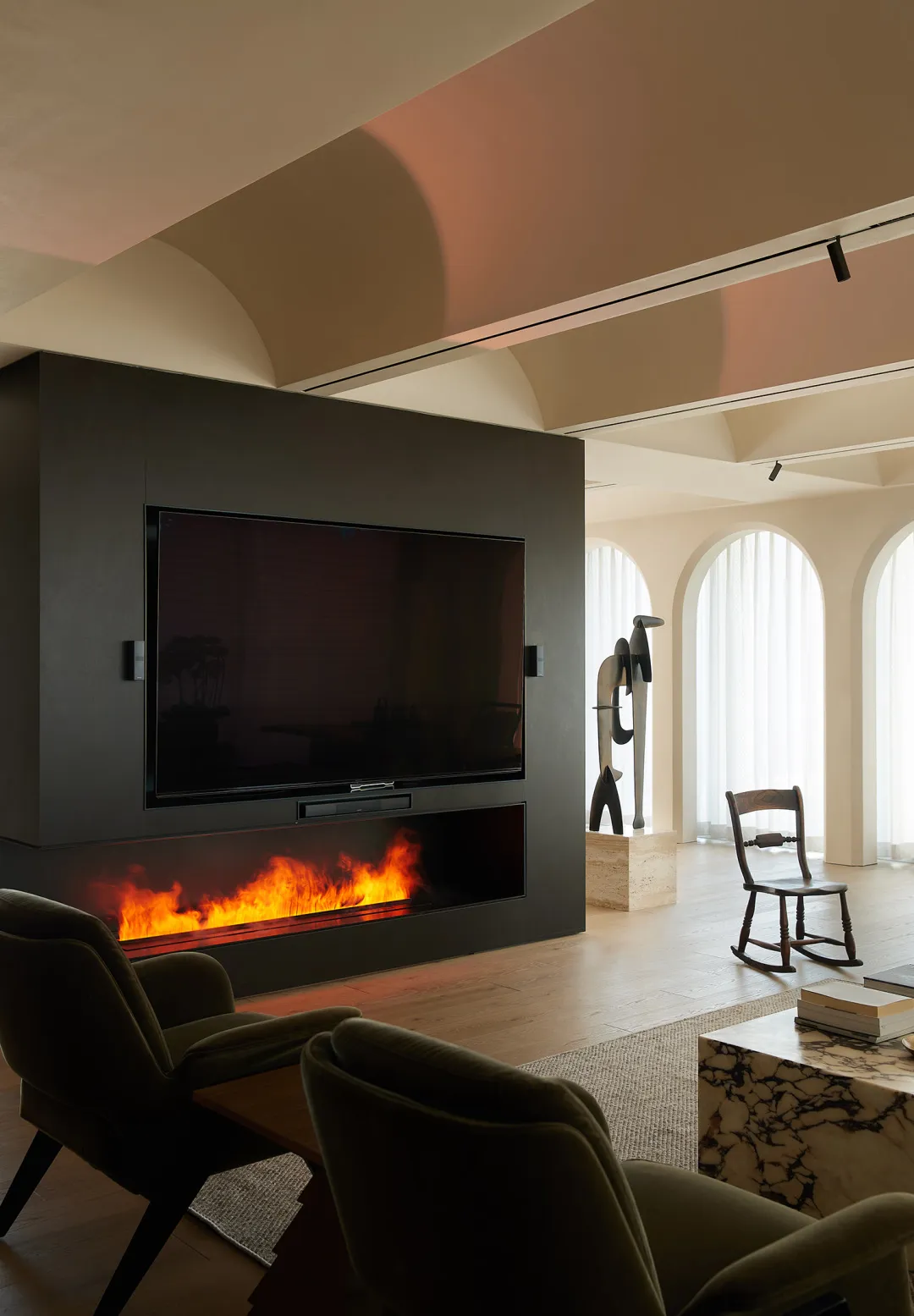 A modern living room with a fireplace, TV, and minimalist decor.