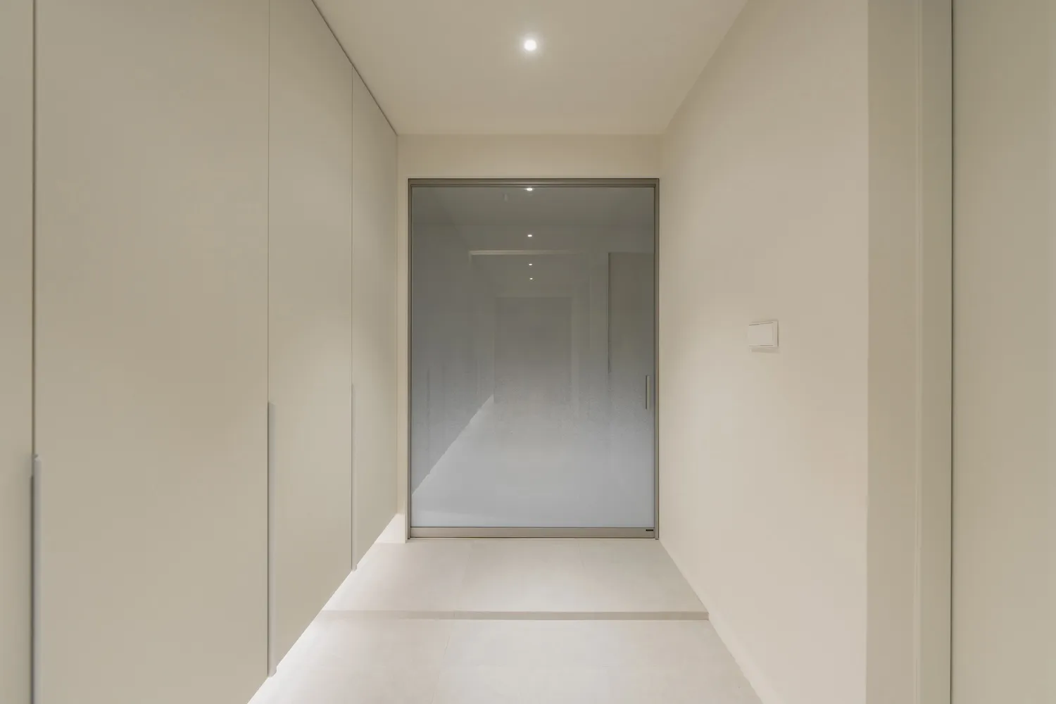 Modern hallway with glass walls and concrete floor