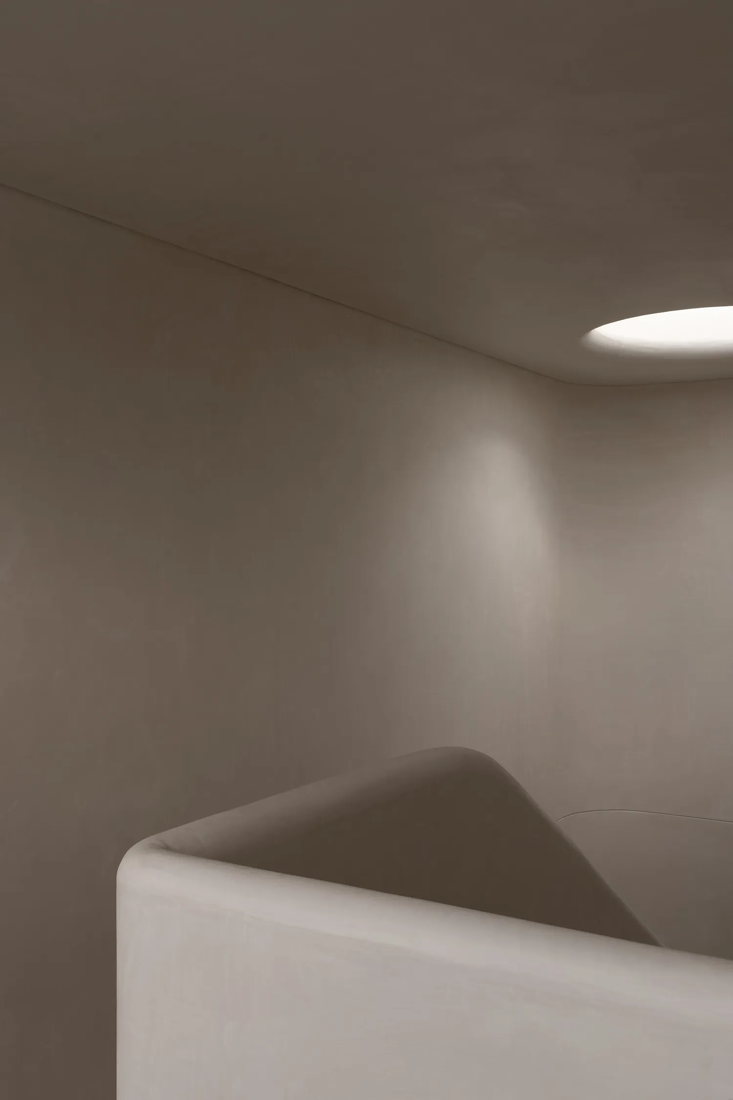 Modern, minimalist concrete staircase with a round light fixture in the ceiling.