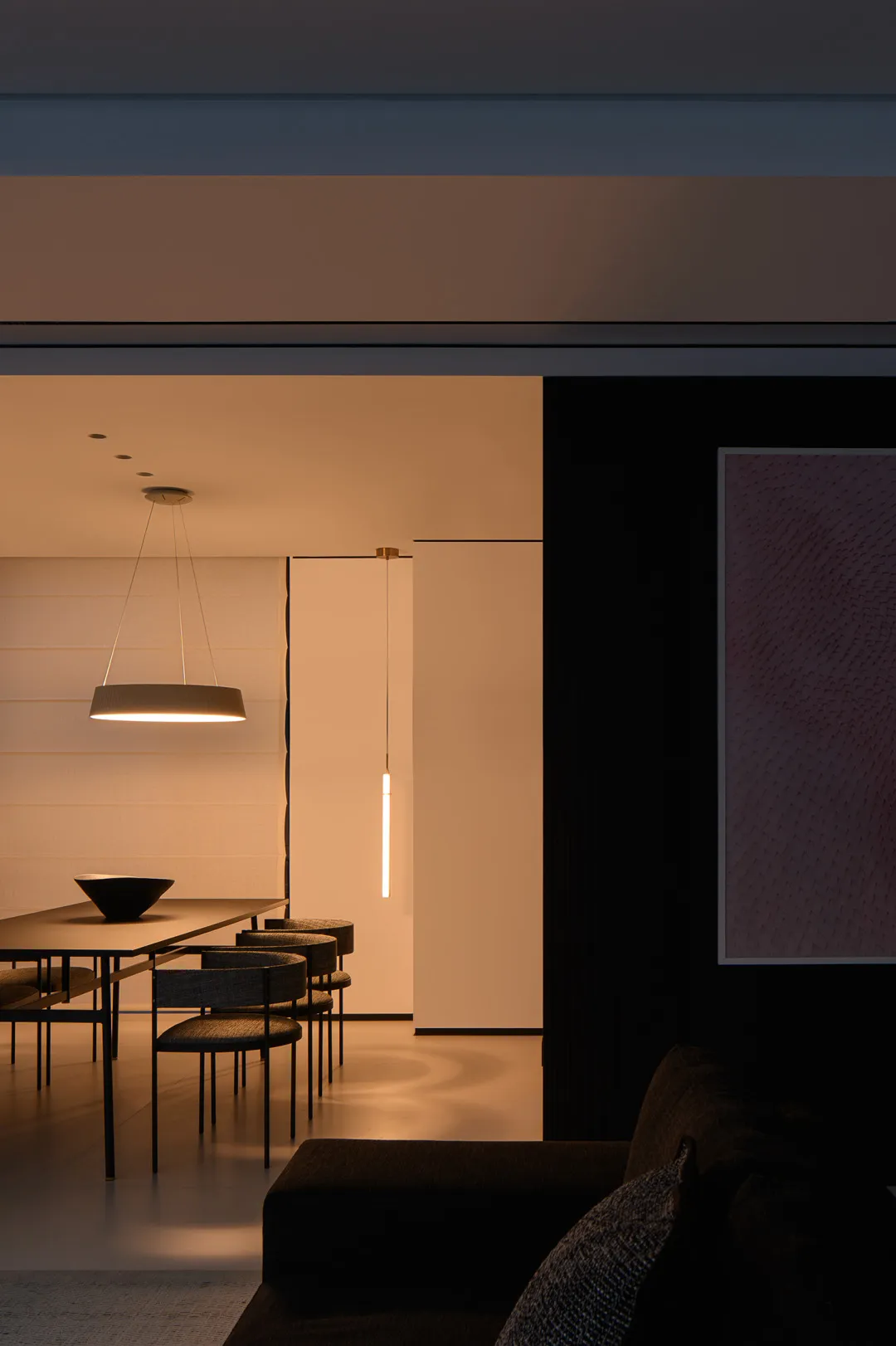 Modern minimalist living and dining room interior with furniture and lighting.