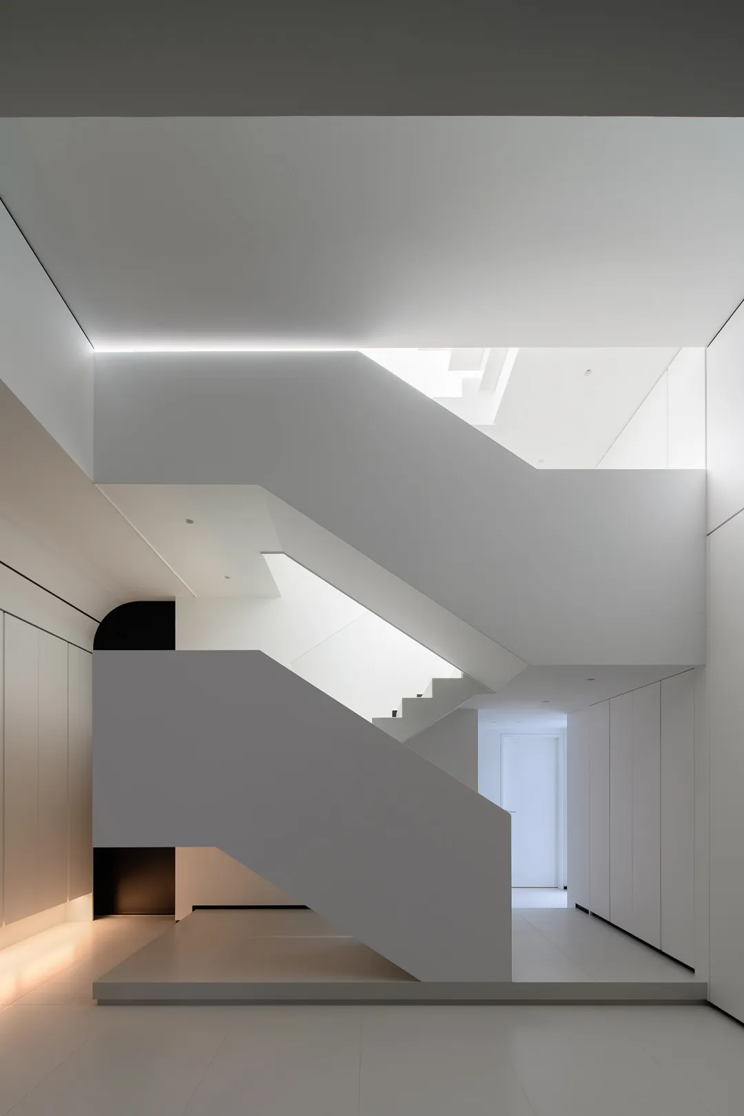A minimalist white interior design featuring a modern staircase.