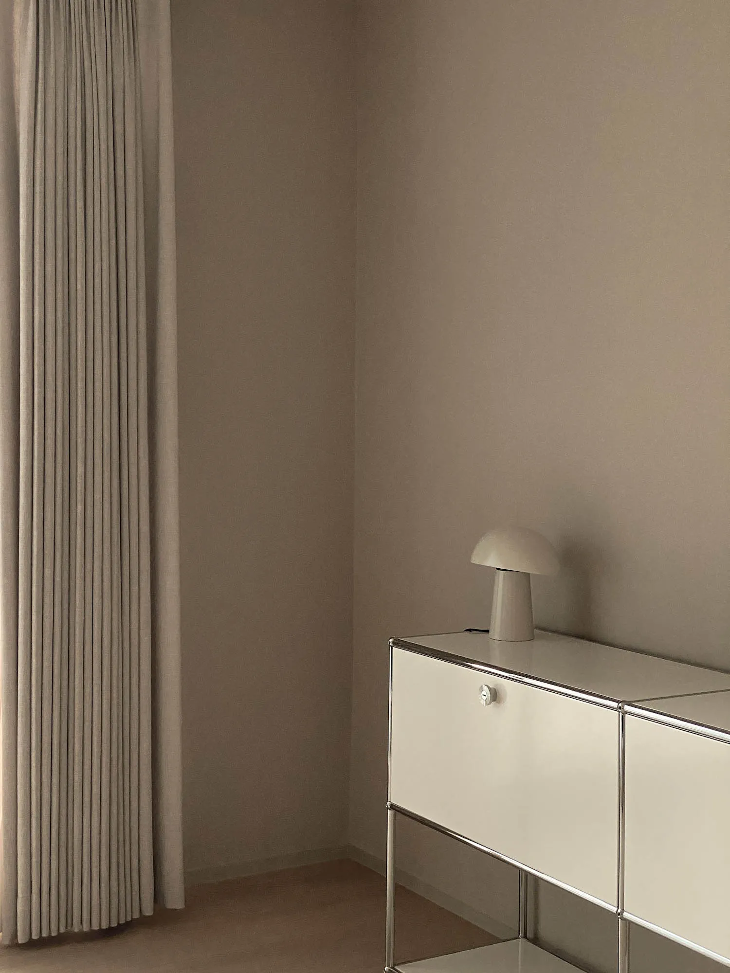 Modern minimalist dresser with white lighting and metallic steel frame.