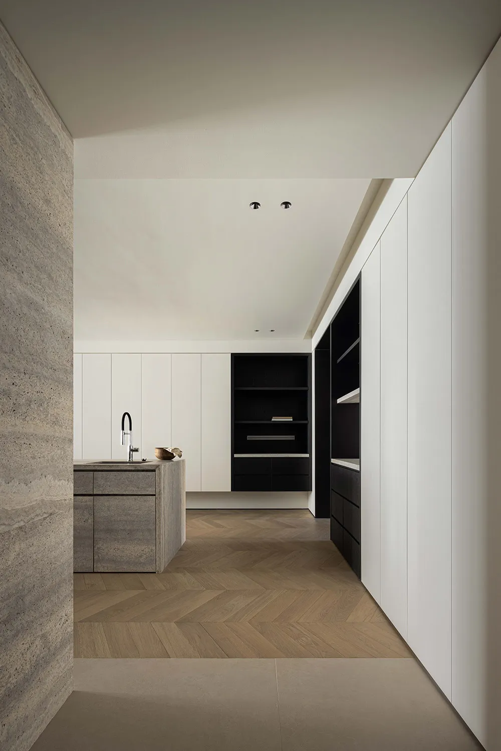 Minimalist residential kitchen featuring textured concrete kitchen island