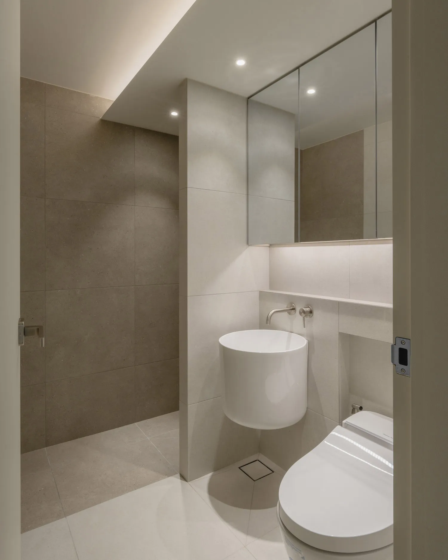 Bathroom with modern design features, concrete tile walls and floor, and minimalist aesthetic.