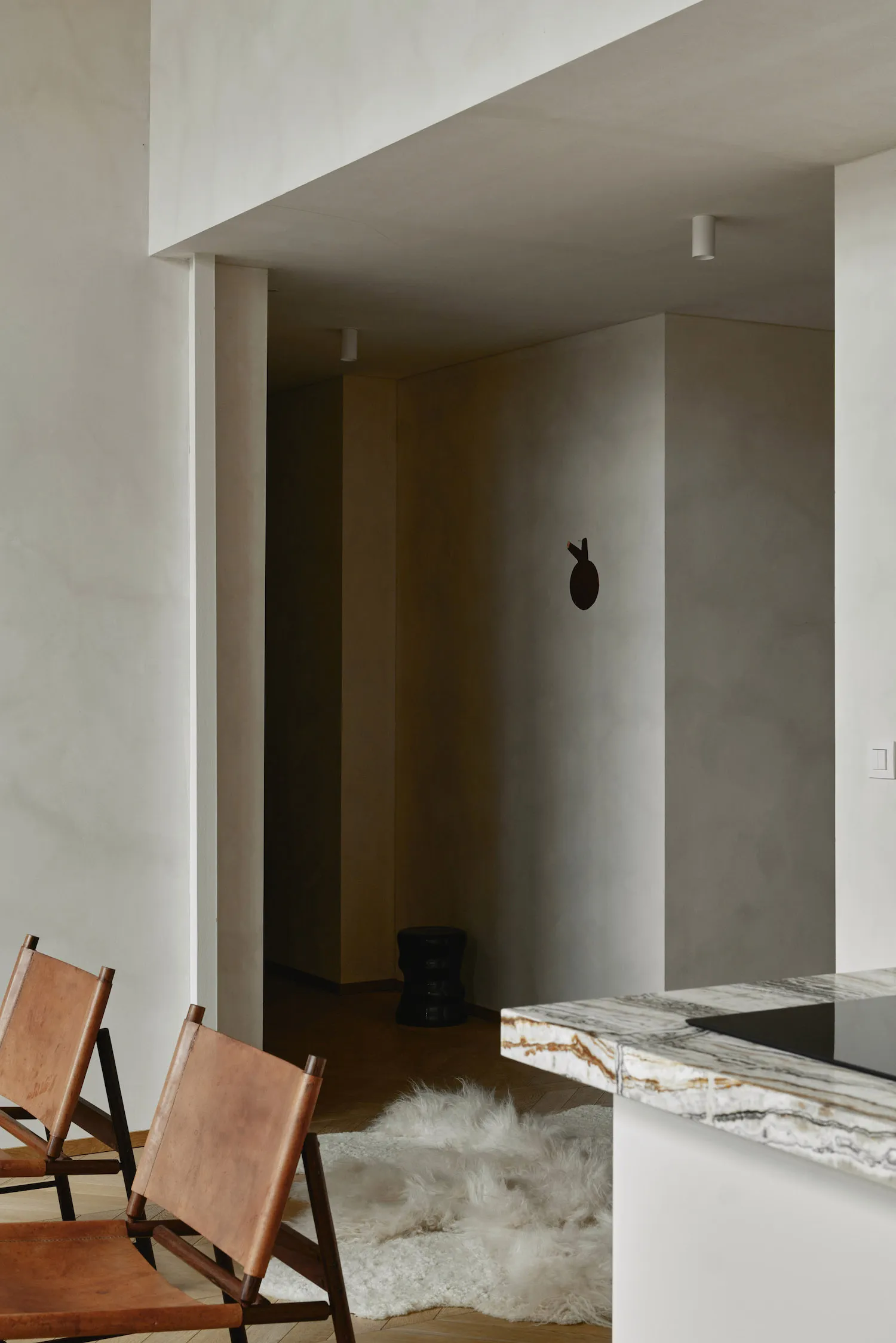 Modern interior design featuring leather, marble, and wooden elements.