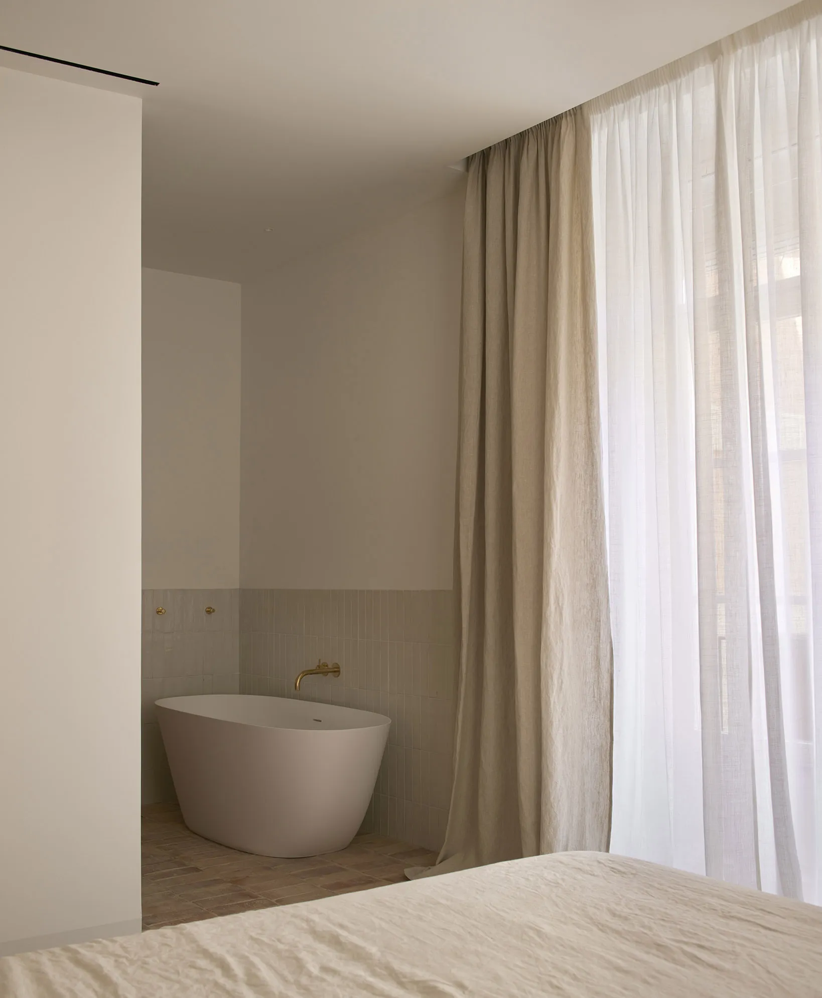 Minimalist bedroom featuring concrete flooring and furniture, creating a modern and sleek ambiance.