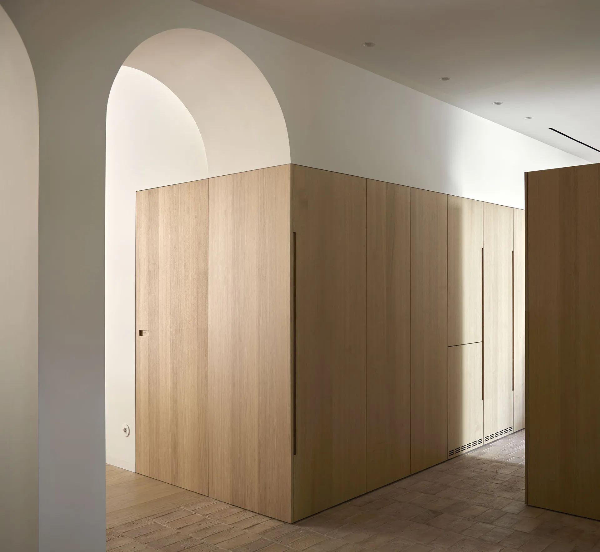 Modern minimalist interior with wooden cabinetry and neutral color palette.