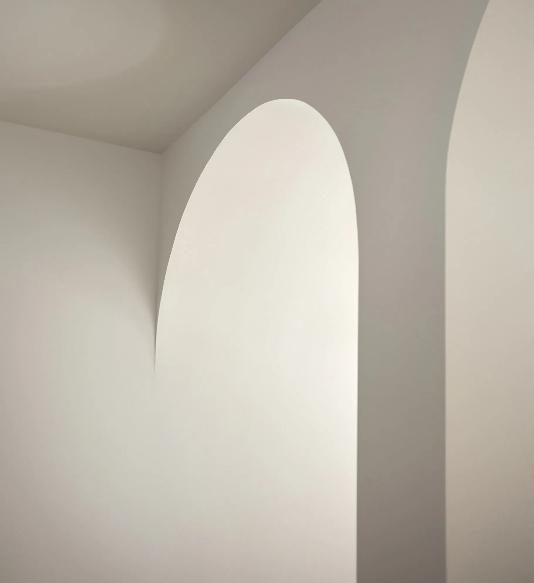 Minimalist white interior with arched doorways and walls.
