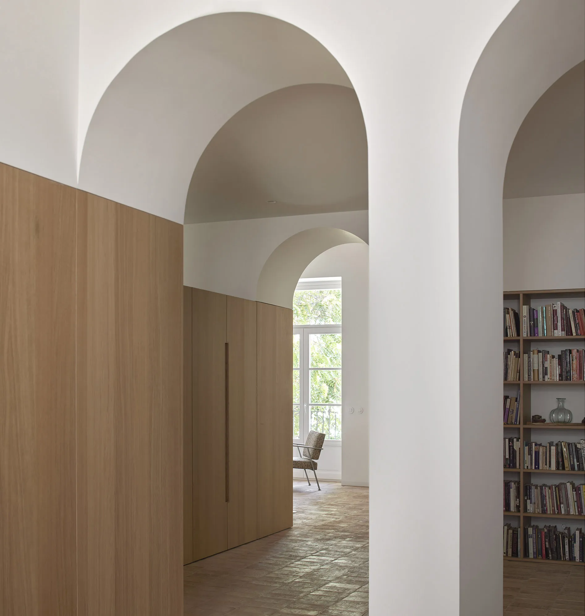 A modern library room with wooden furniture and bookshelves.