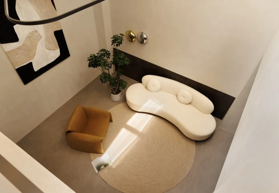 Modern living room with a white circular sofa, textured fabric, and potted plant.