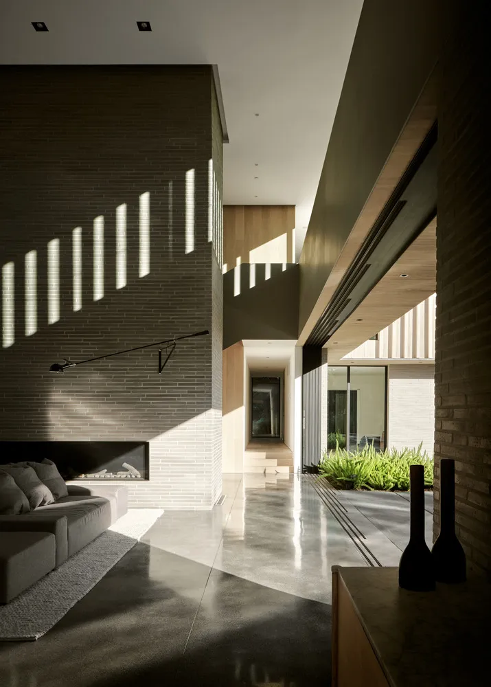 Contemporary living room featuring concrete walls, minimalist furniture, and natural light.