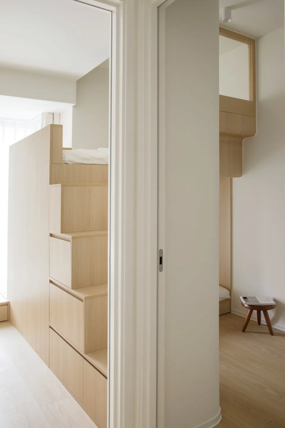 A minimalist bedroom featuring wooden storage units