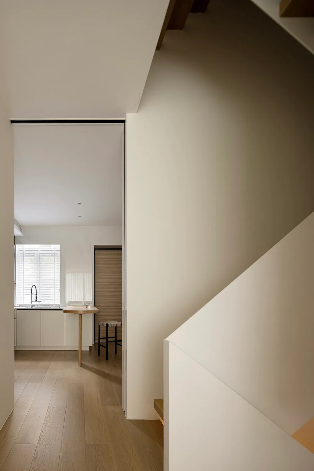 Wooden staircase adjacent to a modern kitchen
