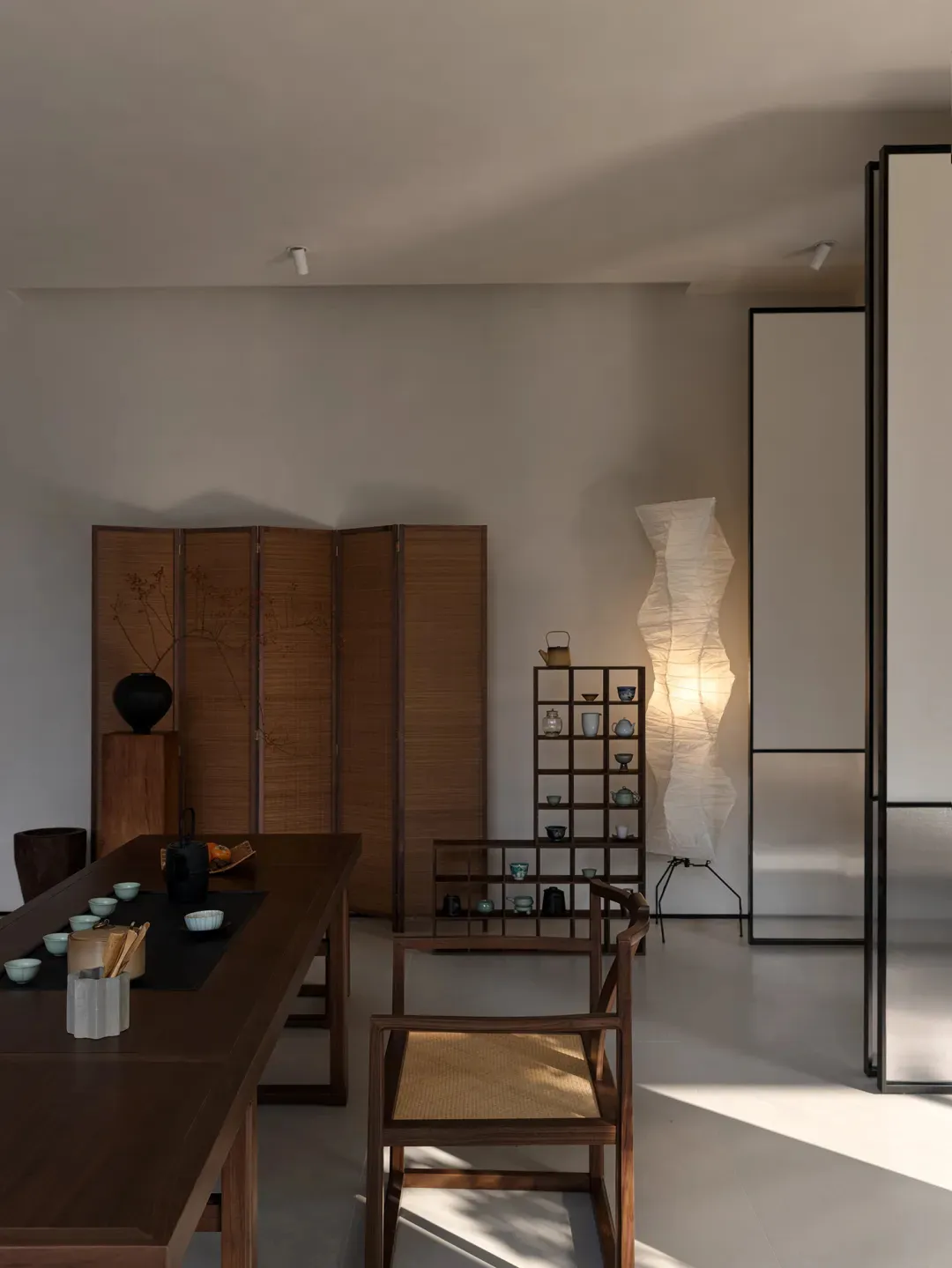 A modern tea room with teak wood furniture and minimalistic decor.