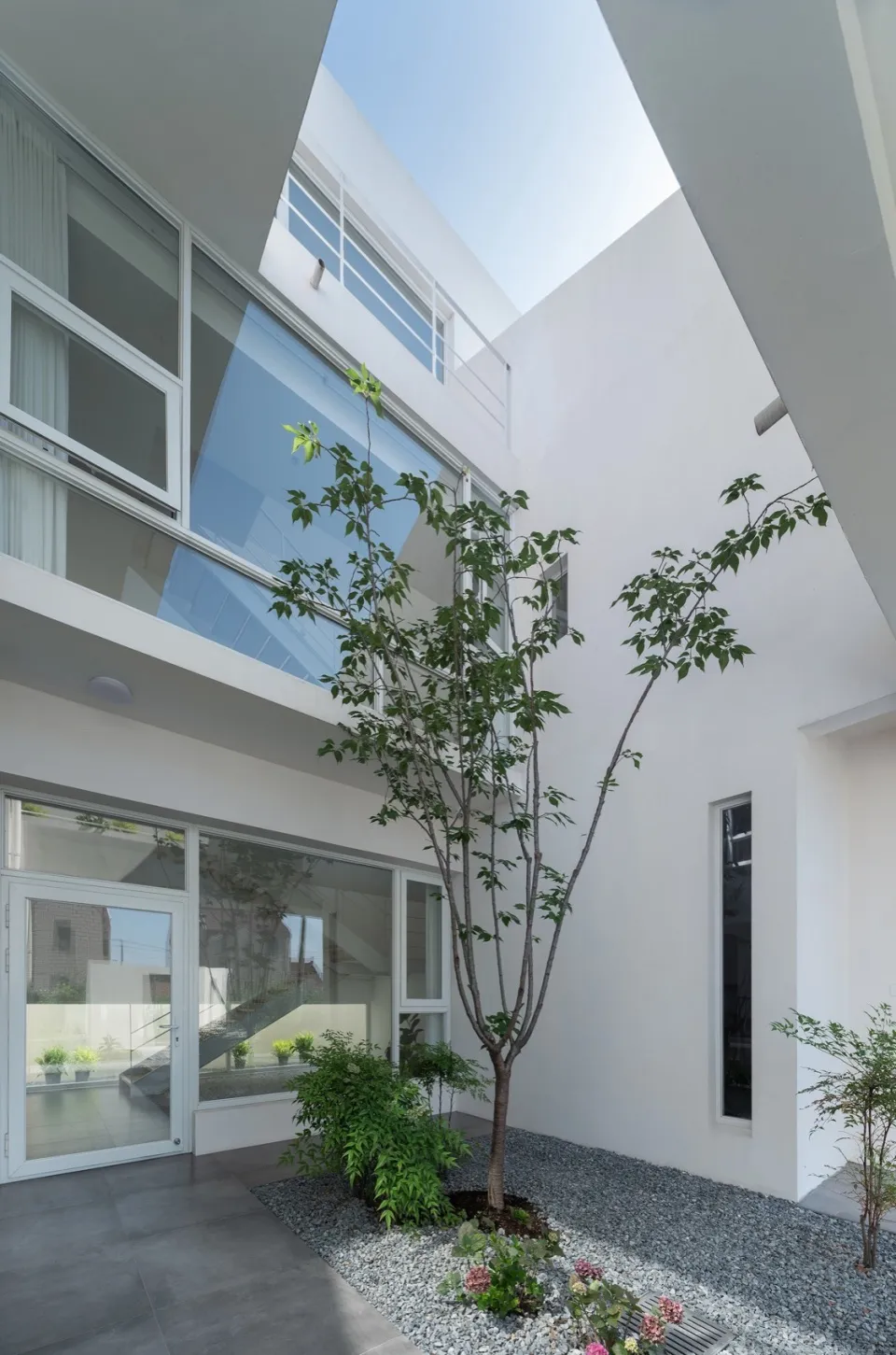 Modern interior space featuring white concrete and glass walls