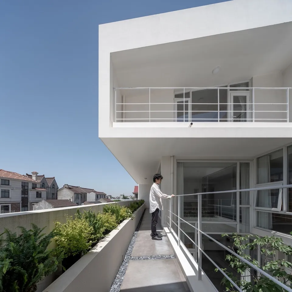 A modern living space with green rooftop plants and concrete walls.