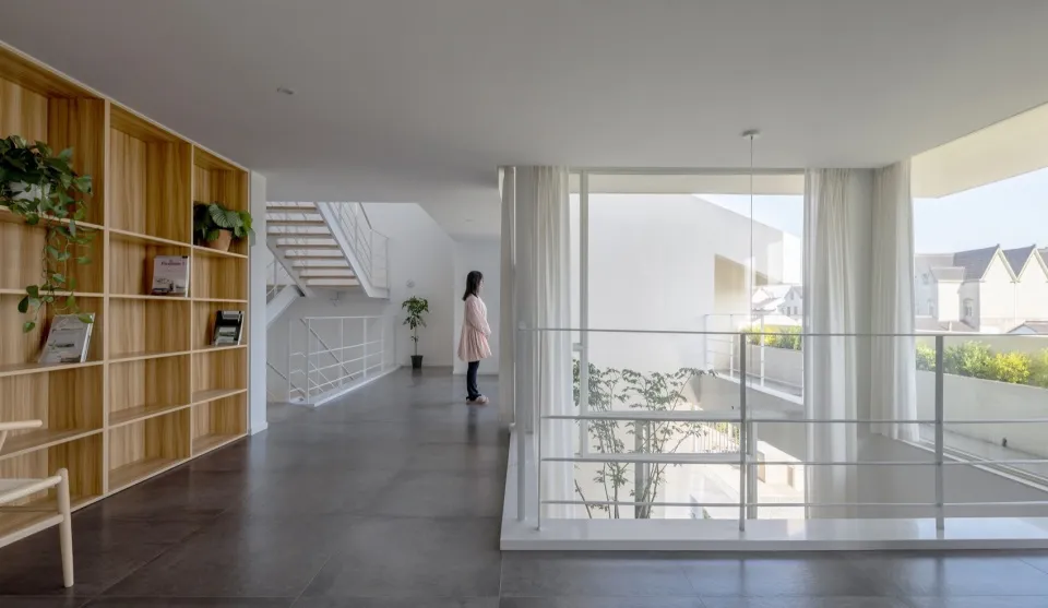 Modern residential entryway featuring glass walls and a concrete floor.