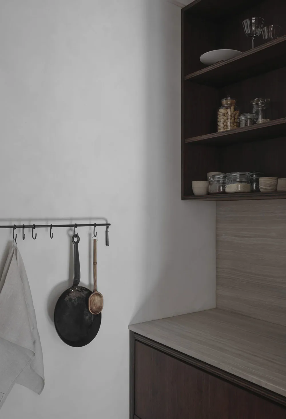 Modern minimalist kitchen featuring concrete countertops and wooden cabinets.