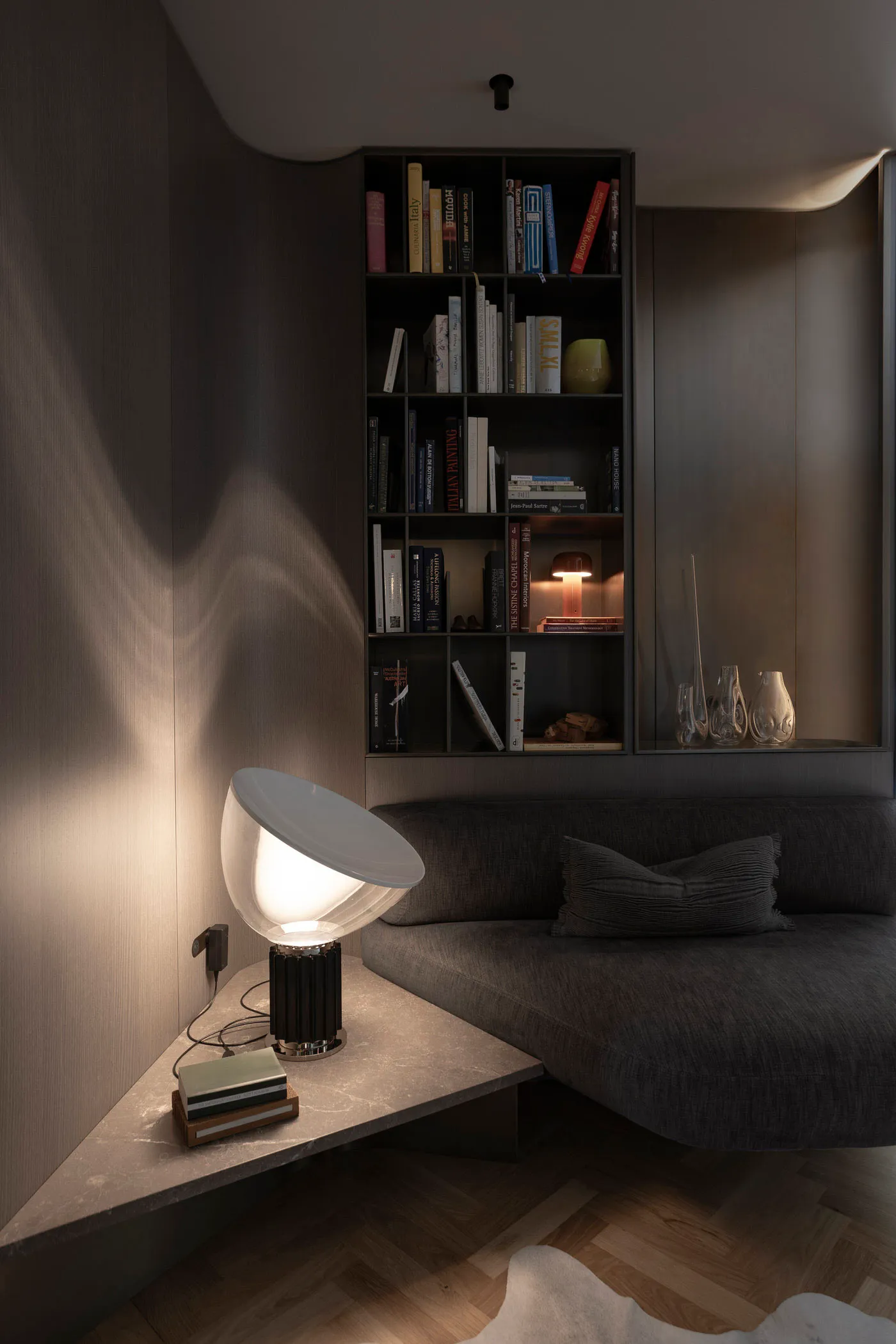A modern living room featuring a sleek, minimalist concrete corner with a built-in bookshelf and contemporary lighting fixtur