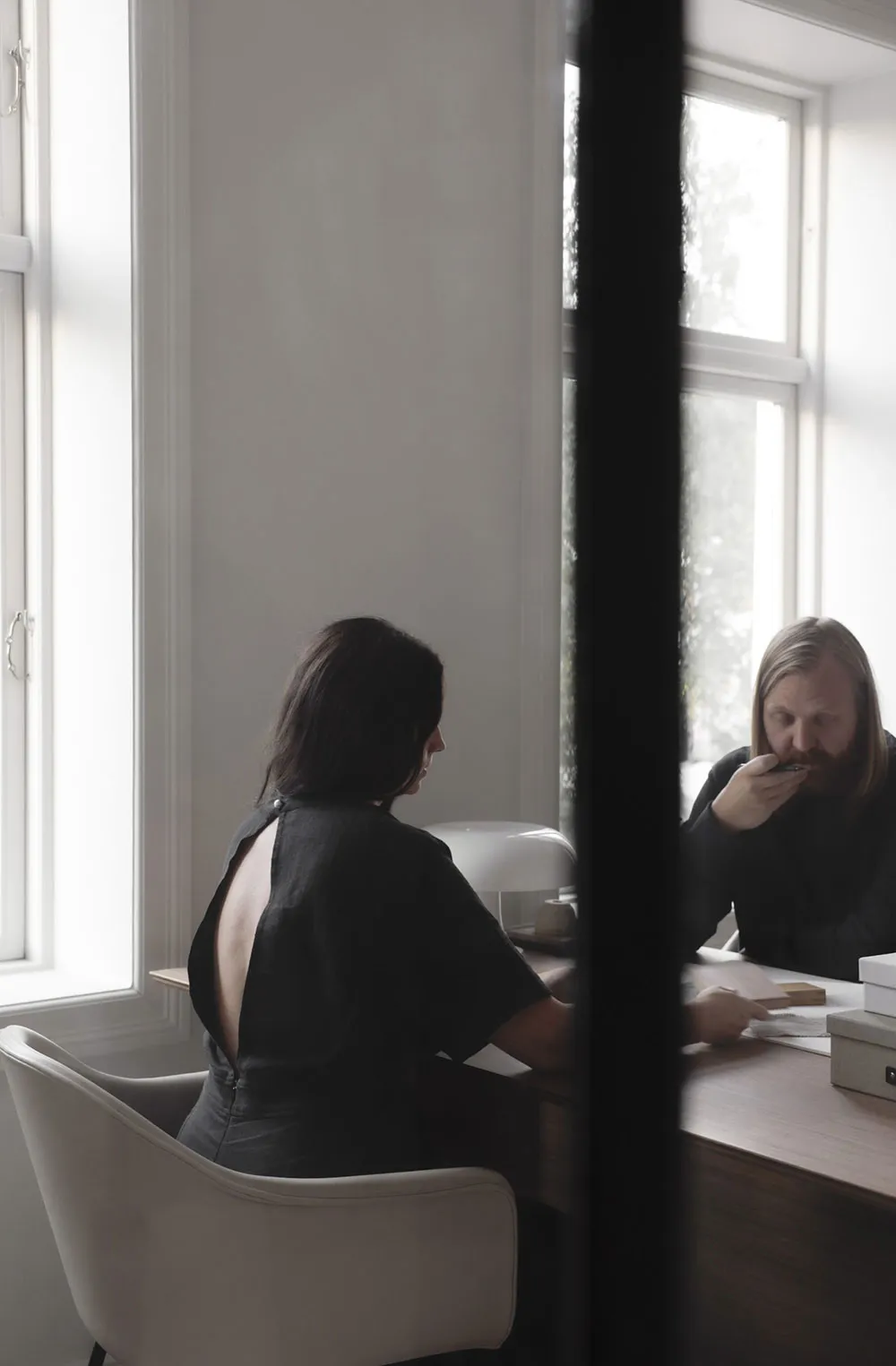 Two individuals engaged in a meeting within a modern office setting.