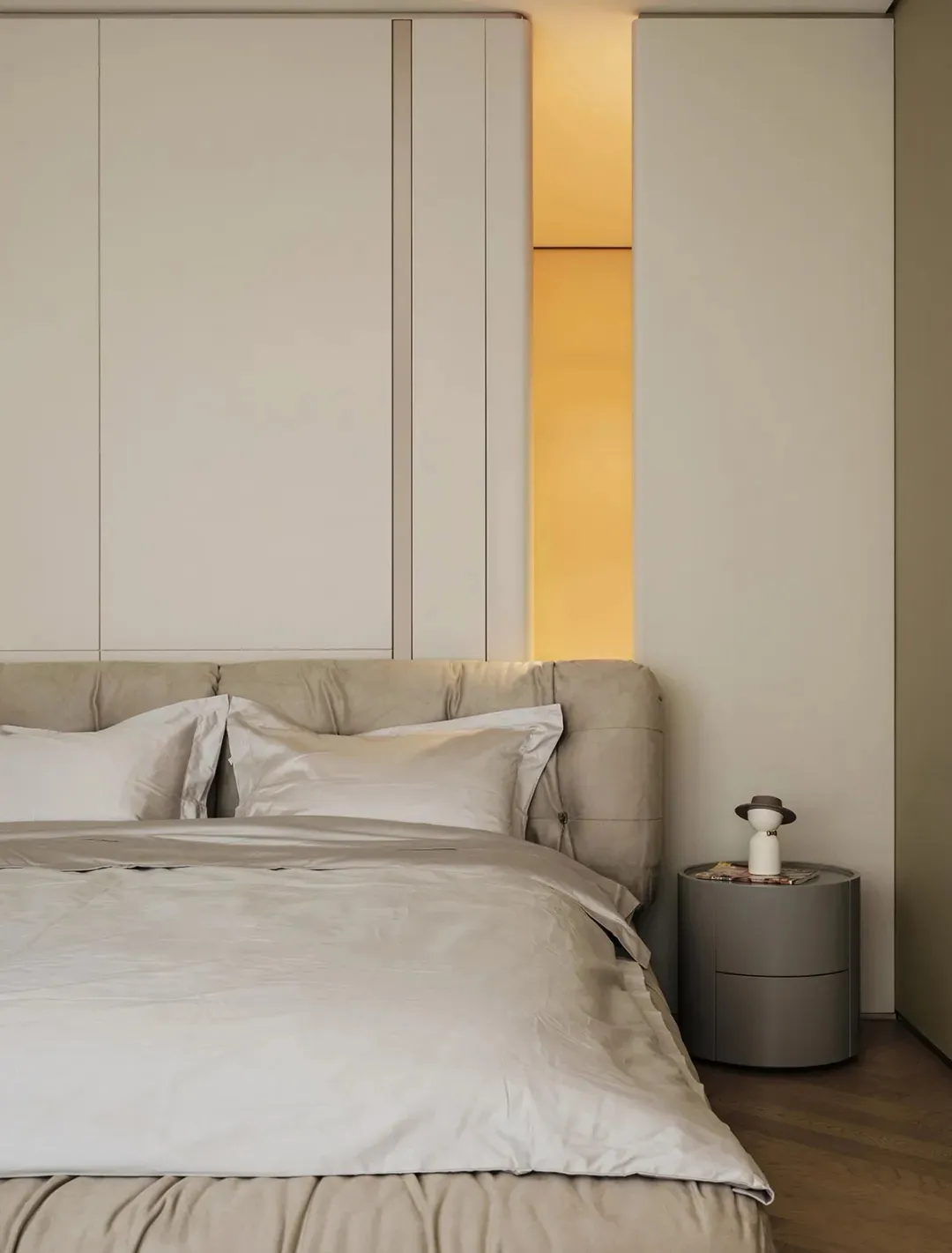 Modern minimalist bedroom featuring a grey fabric headboard made of tufted upholstery, minimalistic design aesthetic.