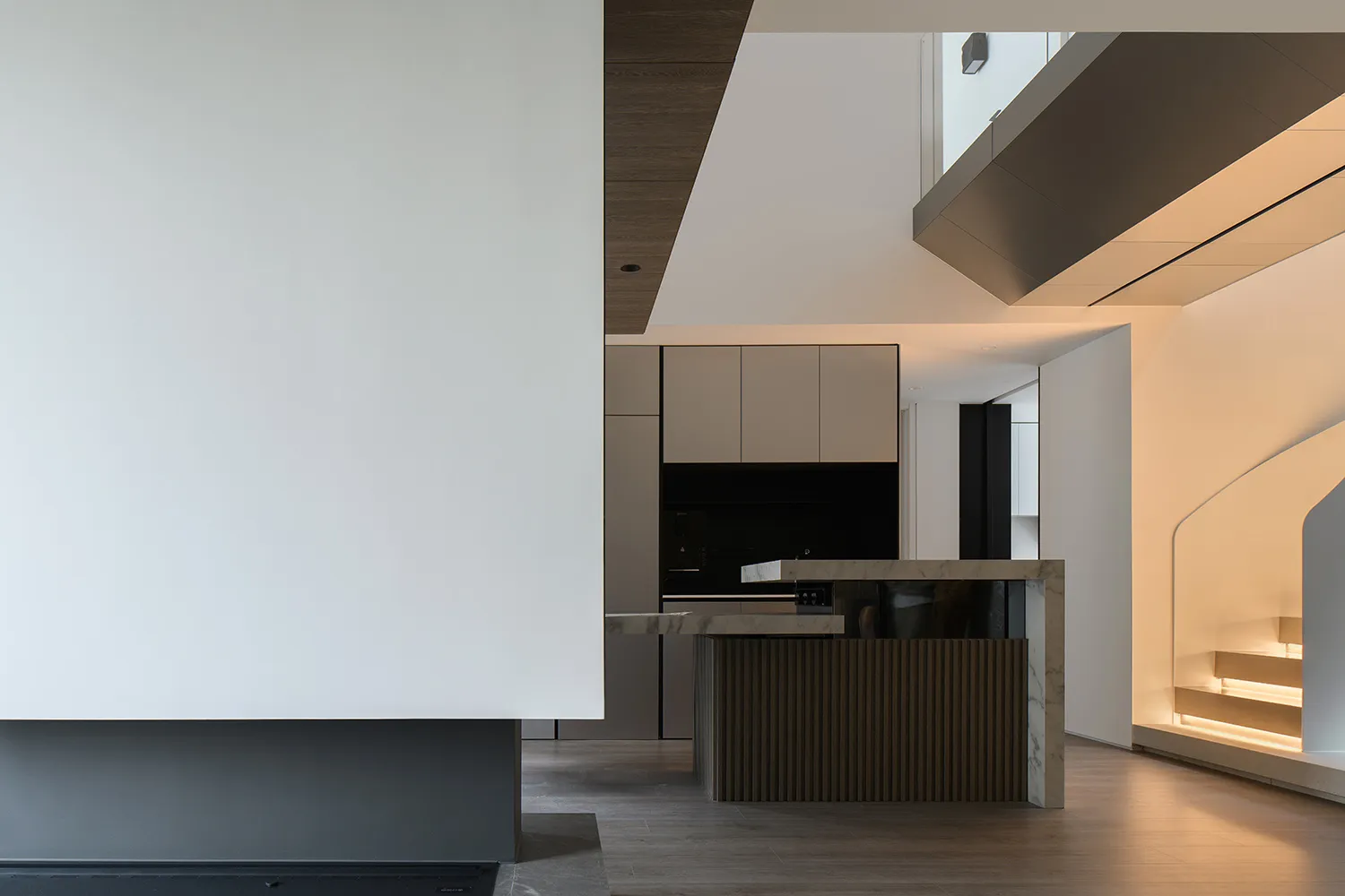 Modern residential kitchen with a marble countertop and wooden cabinetry.