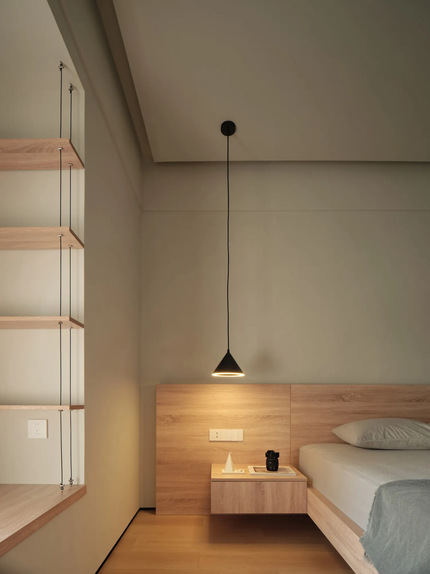 A minimalist bedroom with a wooden bed, floating nightstand, and floating shelves.