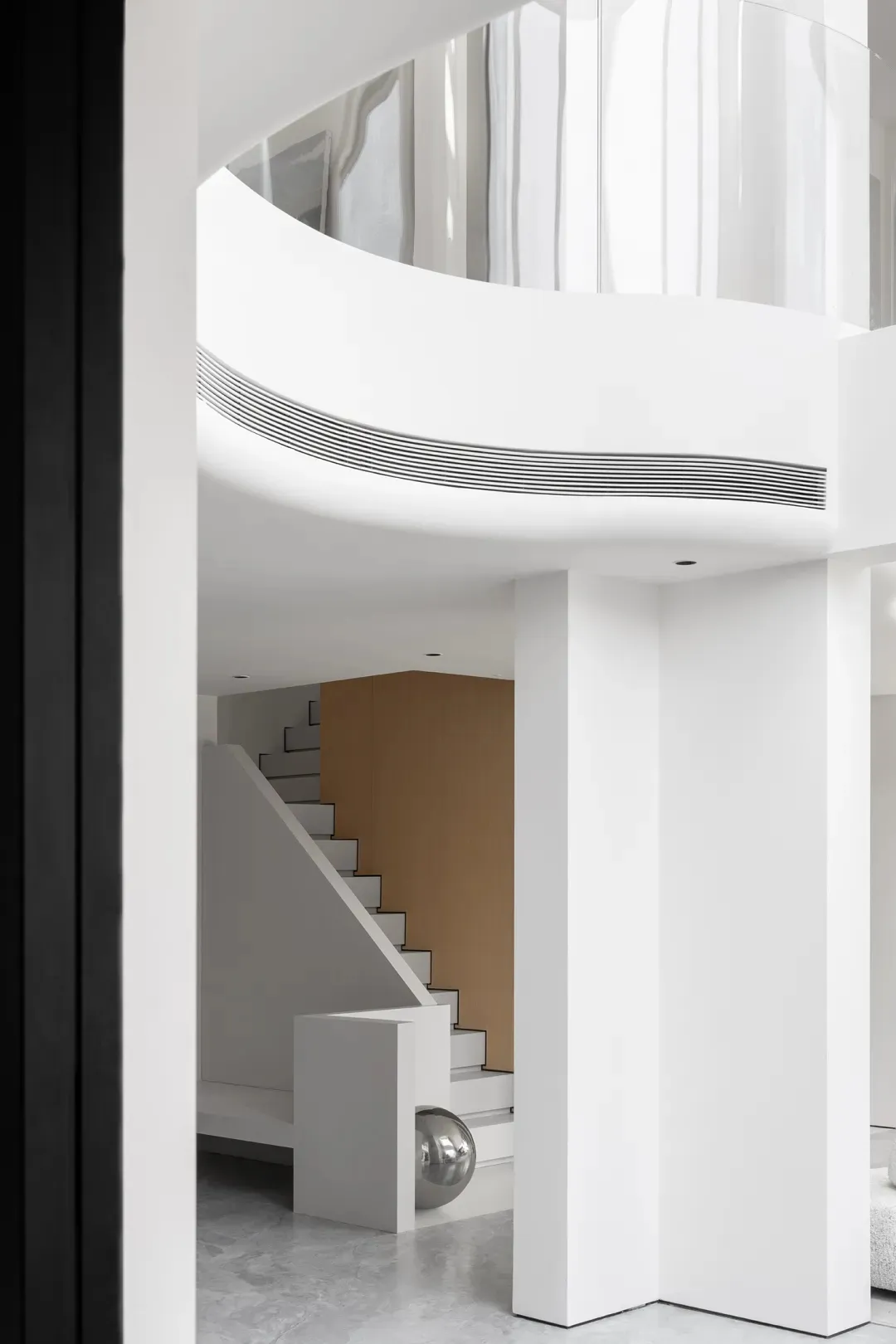 Modern minimalist interior with a white abstract sculpture on a polished floor.