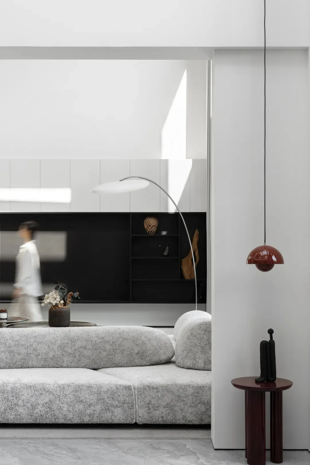 A modern white living room with a textured sofa, minimalist decor, and sleek furniture.