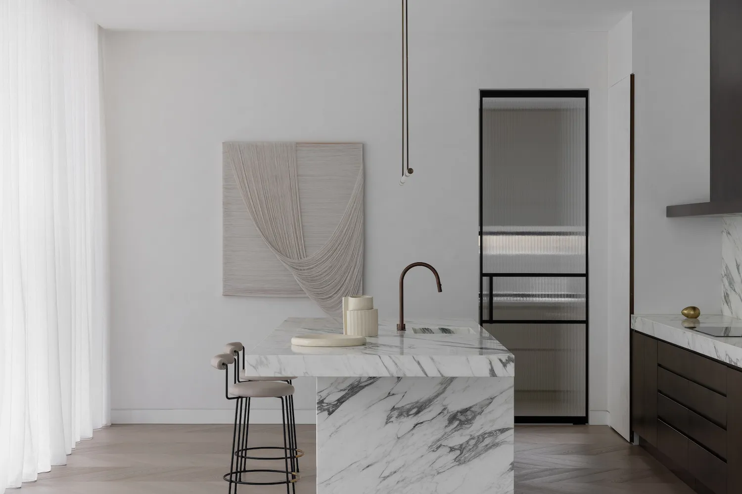 Modern minimalist kitchen featuring white marble countertop and minimalist design elements.