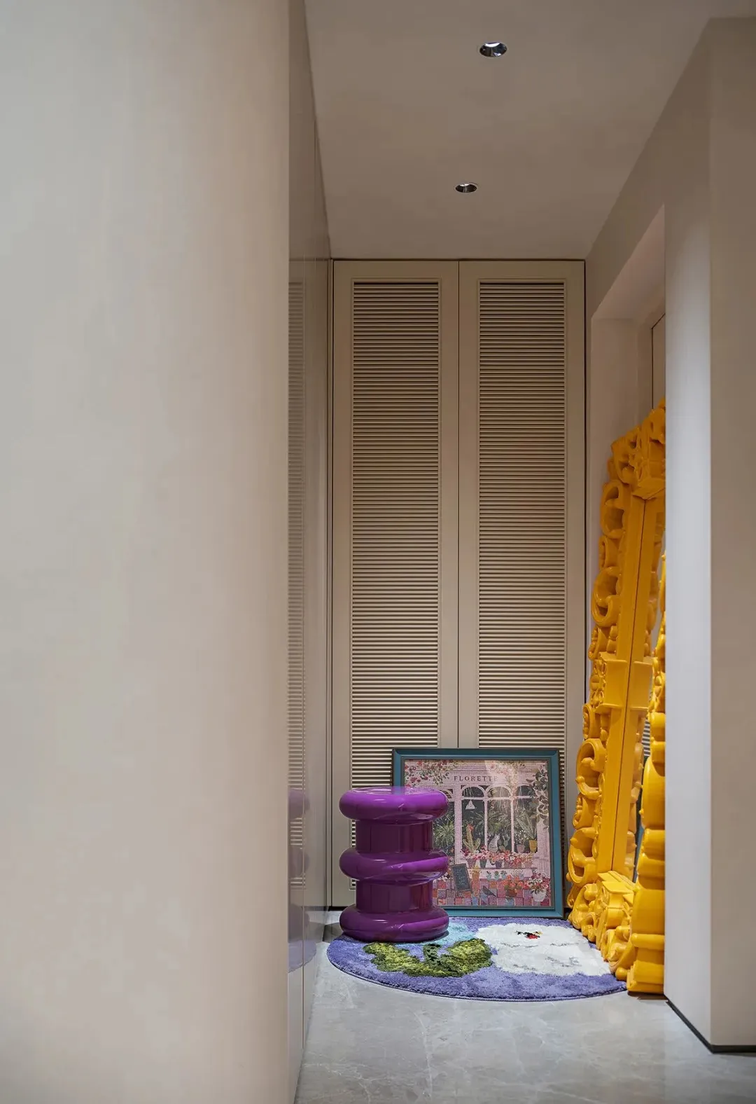 A vibrant hallway scene featuring colorful decor, a textured wall, and a purple stool.