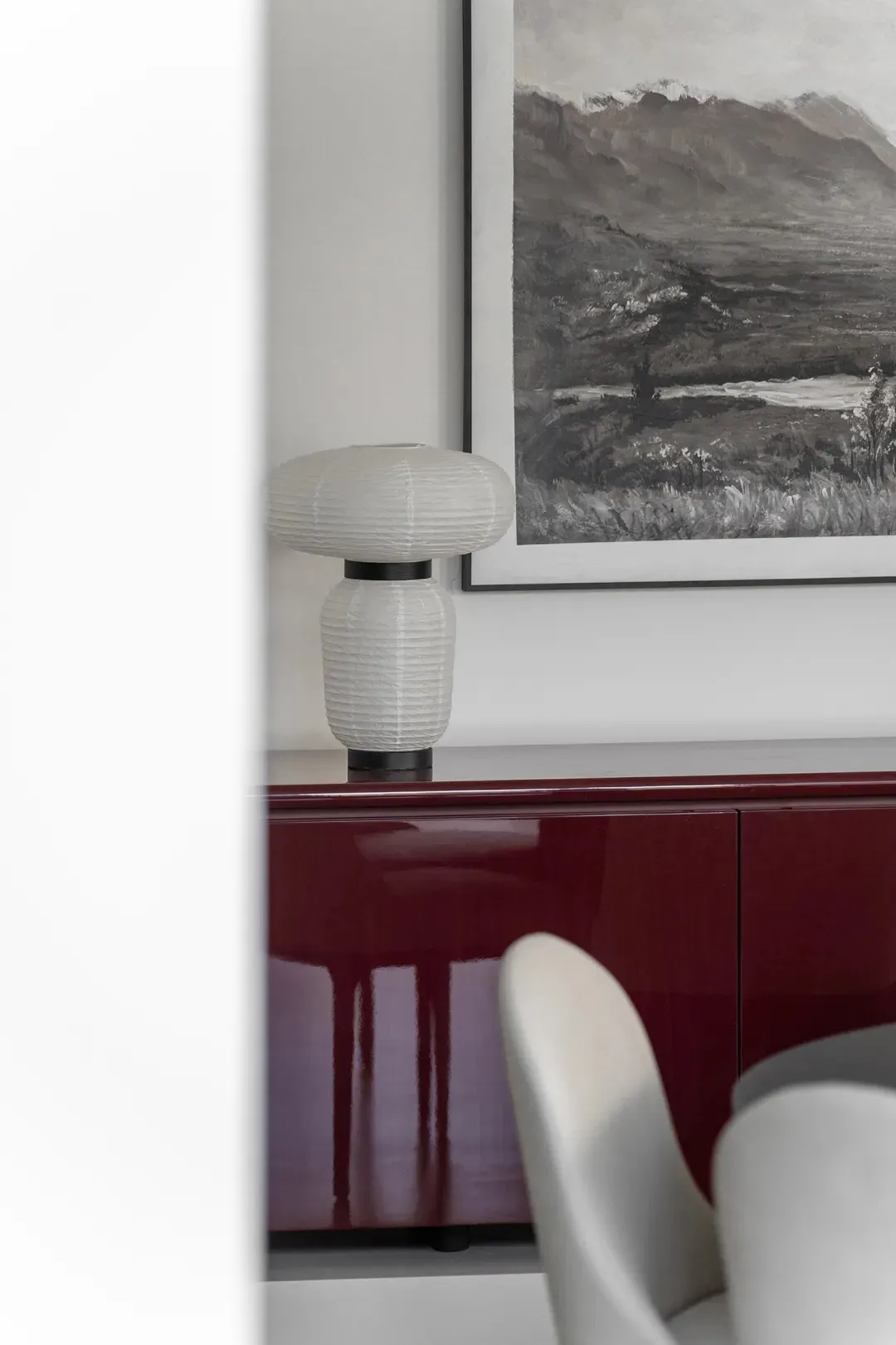 A modern living room featuring a sleek, minimalist design with a striking marble accent table and white accent chair.