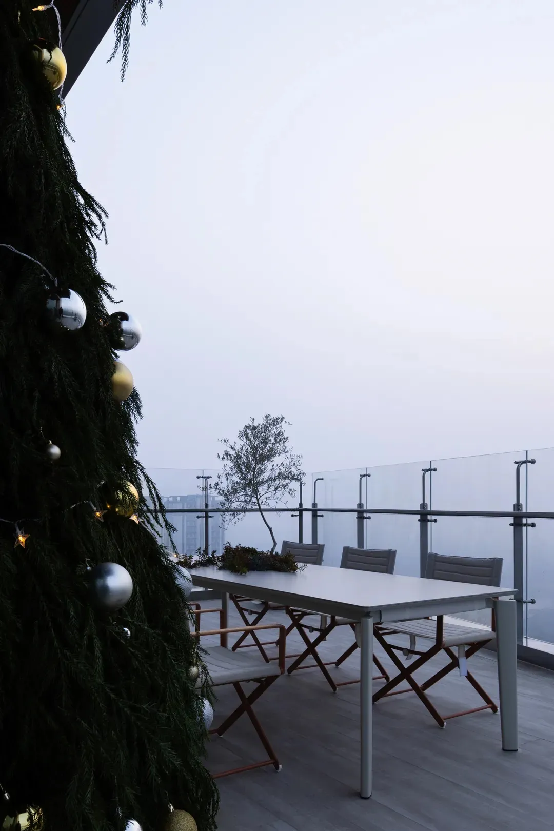 A well-decorated Christmas tree with a table setting in the background.