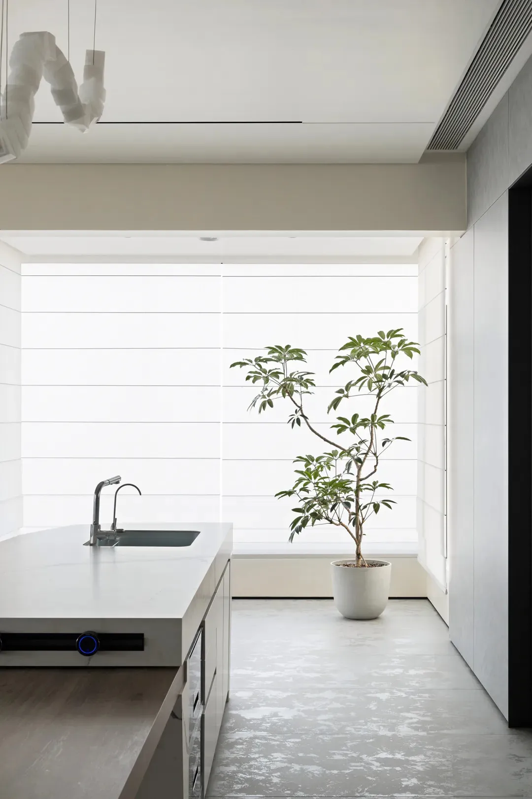 A modern kitchen with concrete countertops and glass elements.