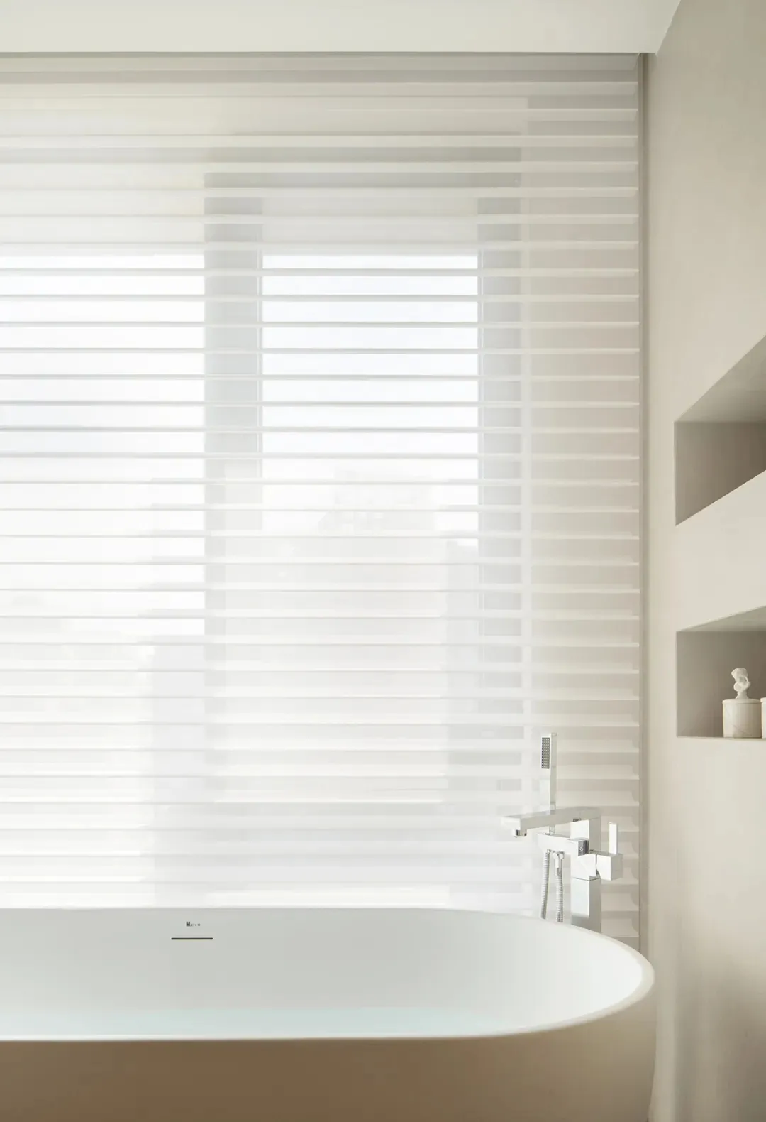 A minimalist bathroom with a transparent glass window featuring horizontal blinds, showcasing sleek design elements in a cont