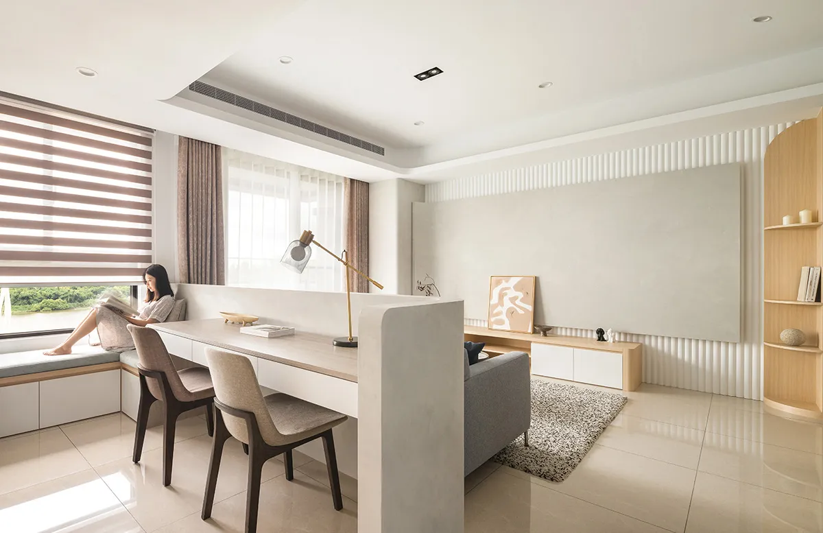 A modern living room with minimalist design, featuring concrete walls and floors, and a sleek, contemporary furniture layout.