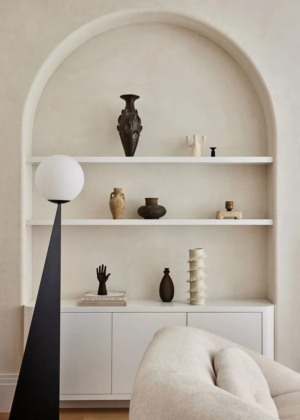 A minimalist living space featuring concrete shelving and ceramic decorations.