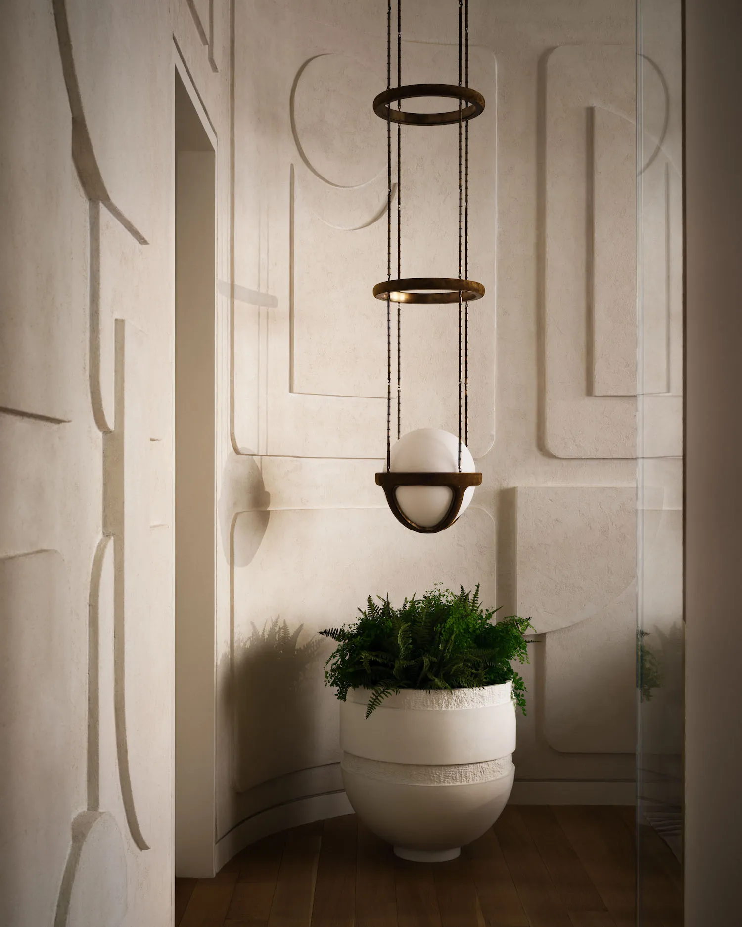 A modern bathroom features concrete planters and a decorative lighting fixture.