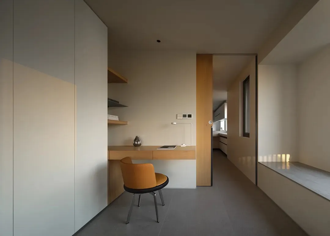 A minimalist home office with a wooden desk and a yellow chair.