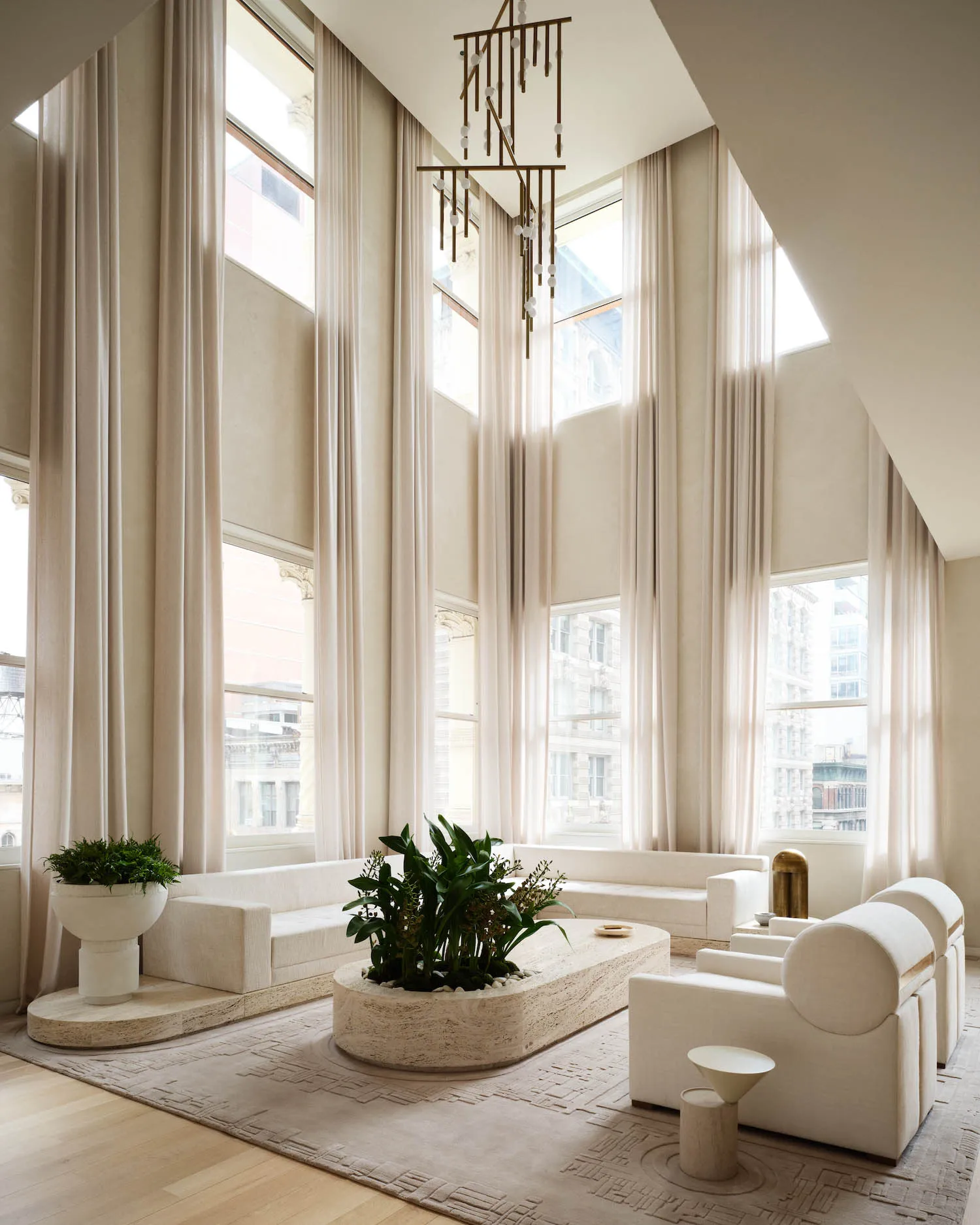 A modern minimalist living room featuring glass windows, a white fabric sofa, and a wooden coffee table.