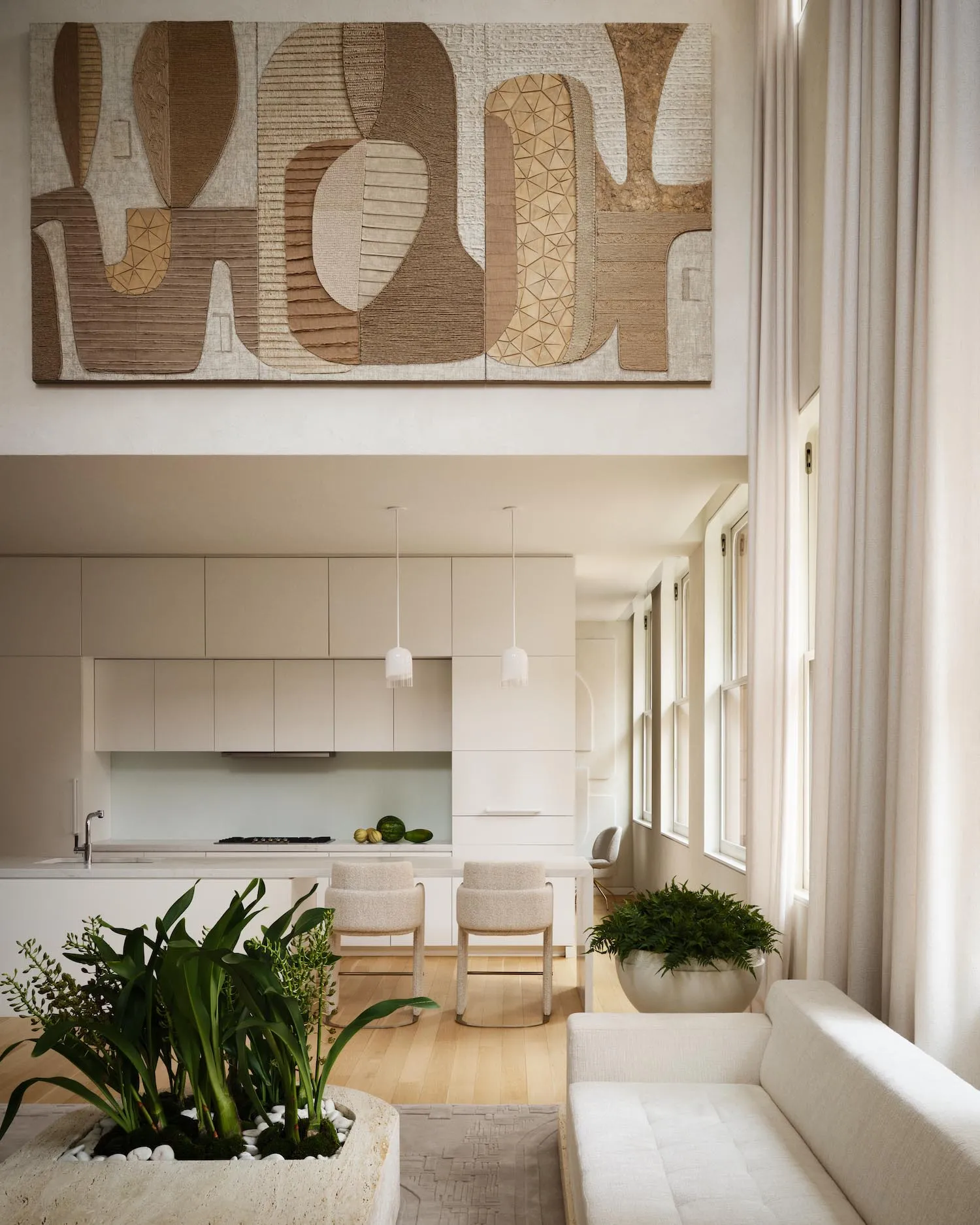 Modern kitchen and living room featuring neutral-toned materials and an open-concept layout.