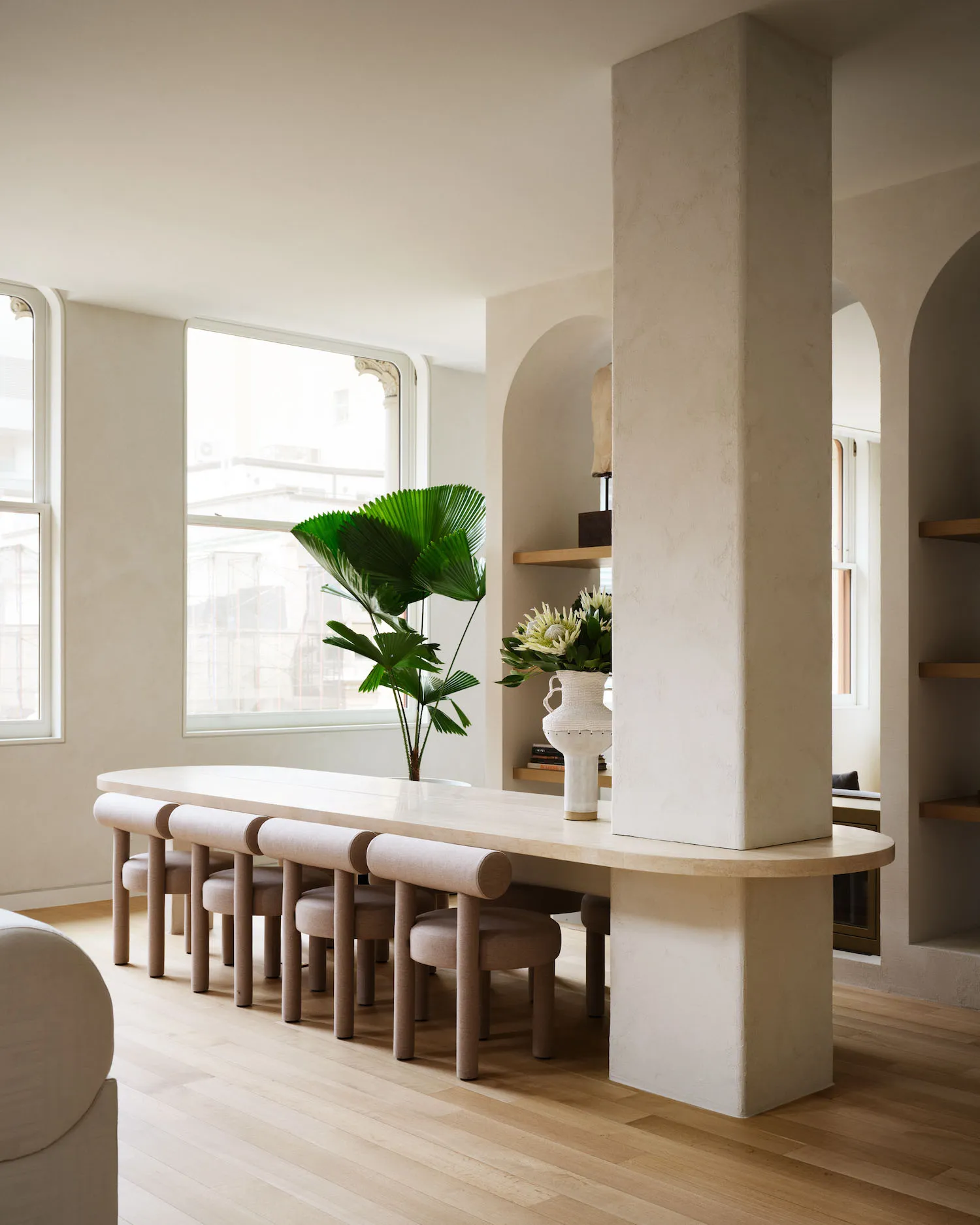 Modern minimalist living room with concrete elements and wooden flooring.