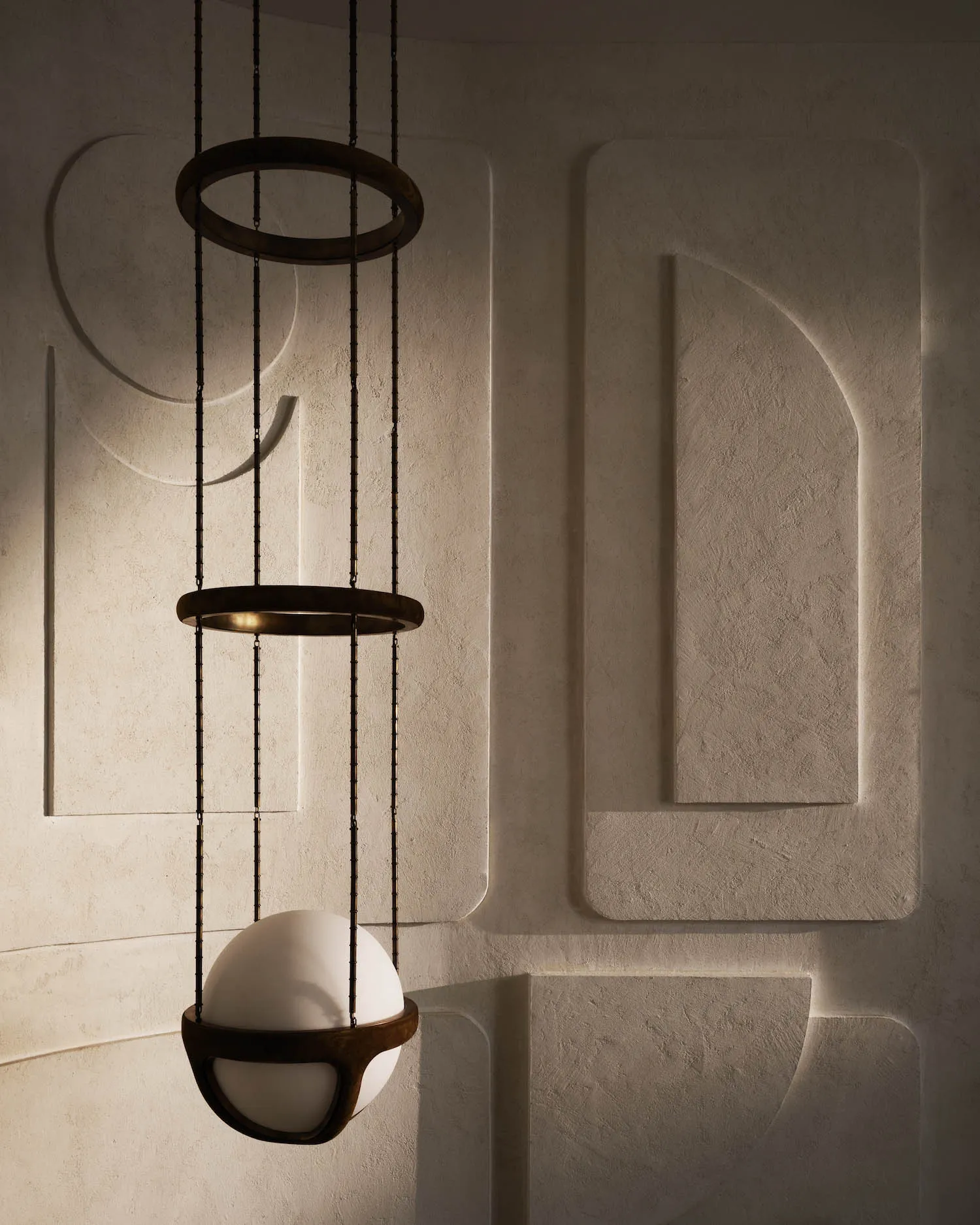 A modern interior space with textured concrete walls and a unique lighting fixture.